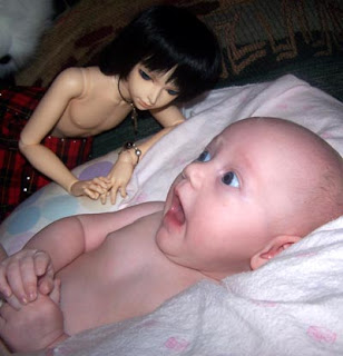 Baby scared by doll