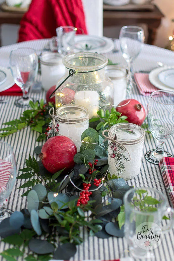 Christmas centerpiece with greenery, candles and pomegranates