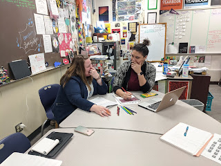 Two teachers look at each other while sitting and planning