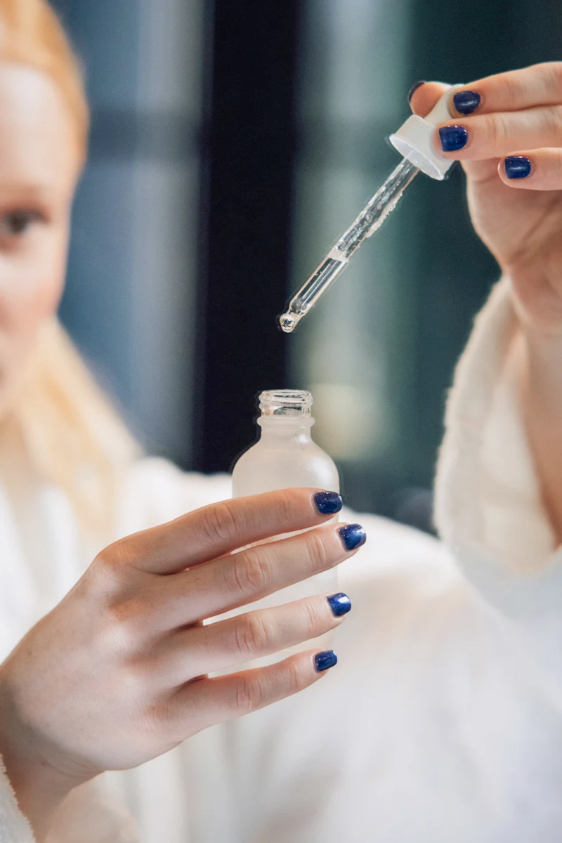 woman holding an opened bottle on retinol serum