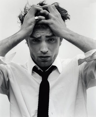 Actor Robert Pattinson holding his head and frowning, unhappily