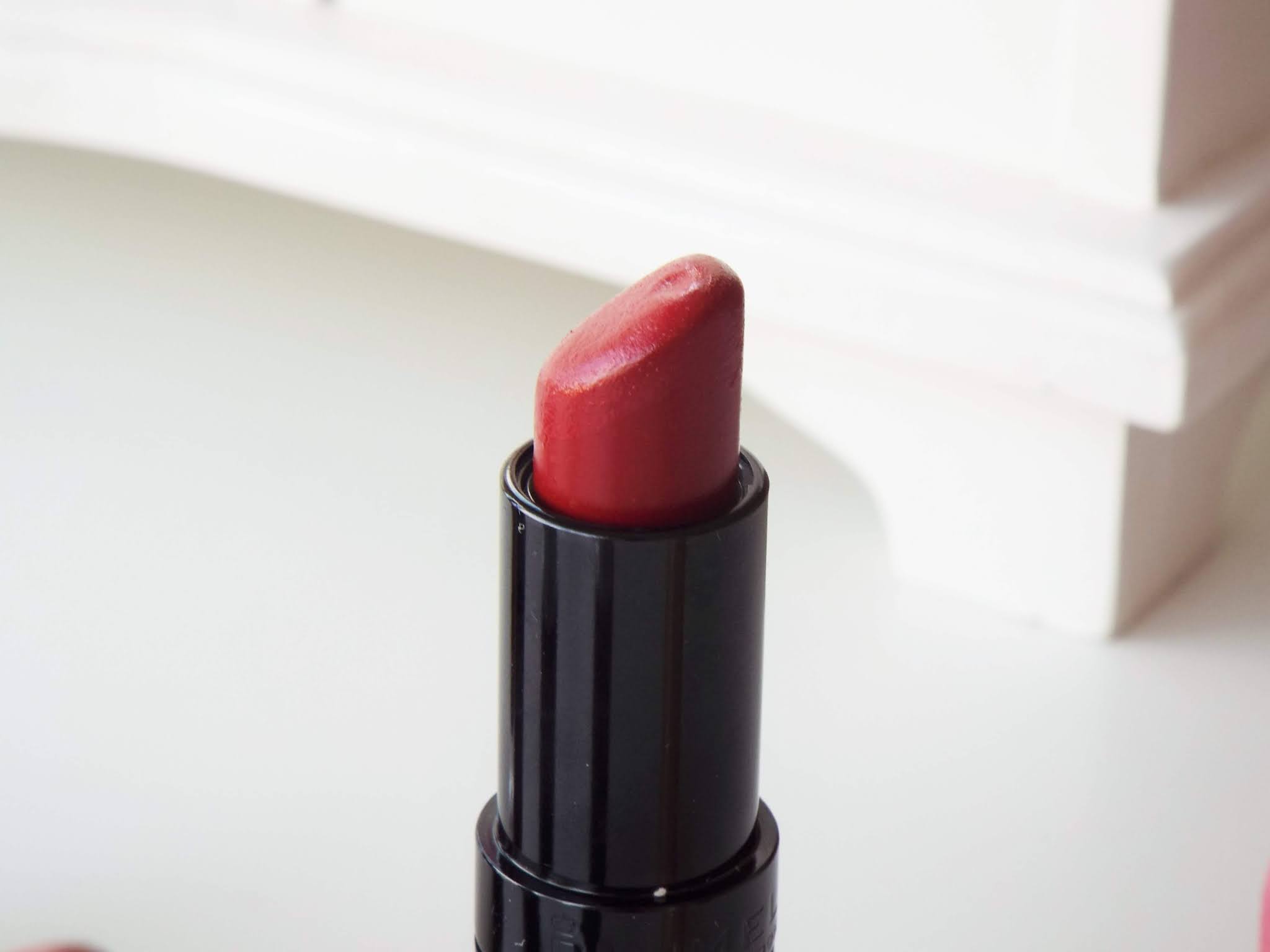 Close up shot of the dark red Rimmel Kate Moss 01 lipstick.