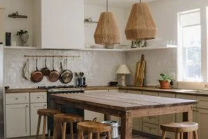 A kitchen with pans made of mixed metals hanging.