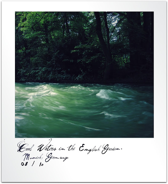 Green trees next to a cool stream in Munich's English Garden.