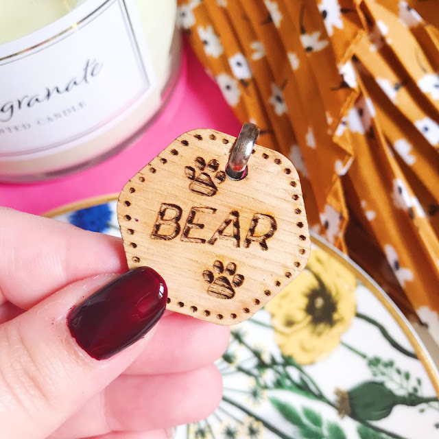 Holding personalised wooden tag above flatlay