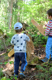 Kinder spielen im Wald mit ihren selbstgebauten Motorsägen aus Holz.