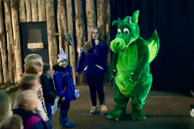 Children queuing up to meet a green fluffy dragon at the Fairies and Dragons event