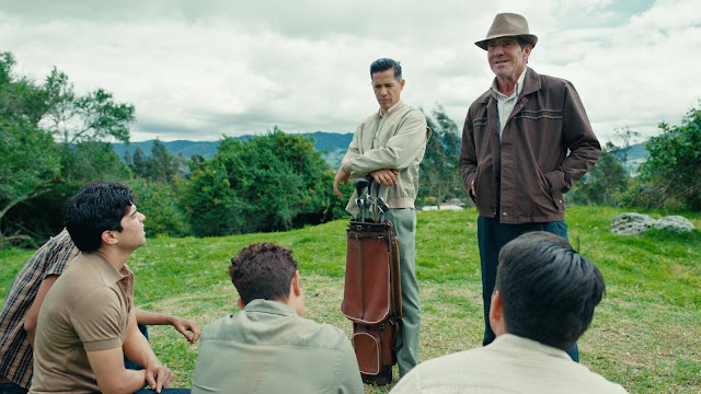 Two men instruct Latino youths about golf