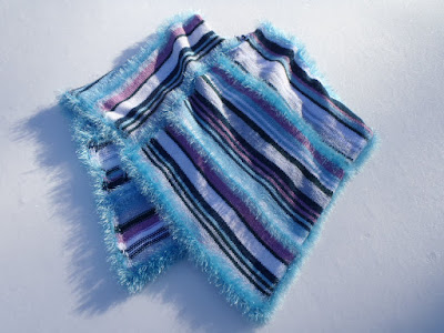 Knitted Poncho with various stripes on a snow covered background