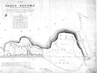 1845 Plan of Upper Bytown Shewing the boundaries as marked on the ground and laid out agreeably to the M. G. & Board's order, with a boundary line added 1848 showing the northern limit of the Sparks property (Lot C, Concession C). Wellington Street is laid out on the left side of the map, with Upper Town lots and building outlines drawn north of it (between modern day Bronson and Bank). South of Wellington Street it just says Mr. Sparks and Kent Street is vaguely drawn. The Rideau Canal's first eight locks are drawn on the right, ending at the Sapper's Bridge. Between Wellington and the Sapper's Bridge is Barrack Hill, modern day Parliament Hill (Lot B). A narrow road connects Wellington Street with the Sapper's Bridge, and this road winds south giving Barrack Hill lots of clearance. Hugged in the southern bend of this road is an area marked Old Burial Ground, and the Lockmaster's House is on the west shore of the Sapper's bridge just southeast of it. Within Barrack Hill there are small footpaths leading to the buildings at water's edge: a row of three buildings, two marked Ruins and the third Soldiers Barracks, a Stable, Officers Quarters, Store, Gardens, Cook House, Privy, Guard House, Commissioner Wood Yard, Well, Tanks, and a zigzag footpath down the hill to the Commissariat, modern day Bytown Museum.