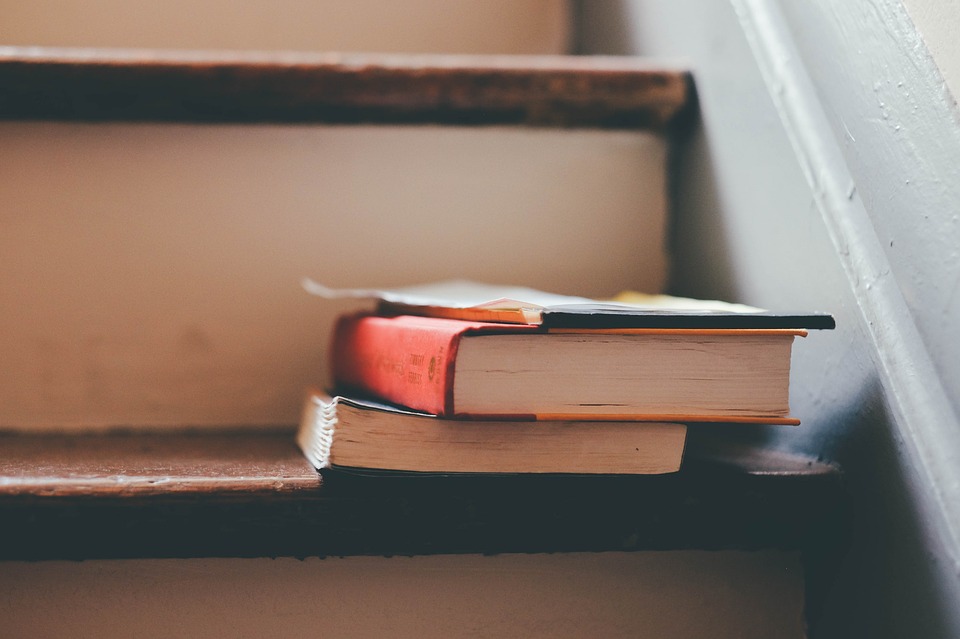 Old books stacked on top of a ladder