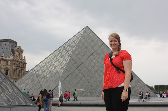 Meagan in front of a glass pyramid at the Louvre