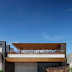 Fachada de casa contemporânea revestida com concreto e madeira + paisagismo com Capim do Texas Rubro!