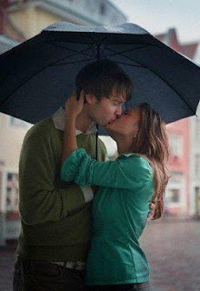 couple kissing under umbrella in rain