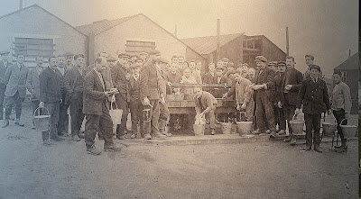Black and white photo showing group of male internees doing their washing