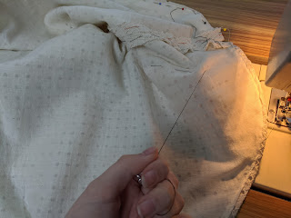 a hand pulling basting threads out from the skirt