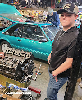 CJ stands next to the 357-cubic inch V8 on the engine stand.