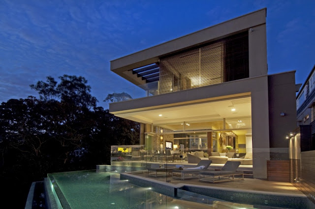 Modern home with its swimming pool and terrace from the backyard 