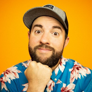 Matt Giovanisci in a Hawaiian shirt on an orange background