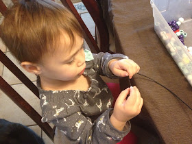 toddler playing with wooden beads