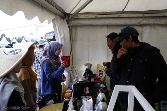 Interaksi barista dan pengunjung yang bertanya tentang kopi