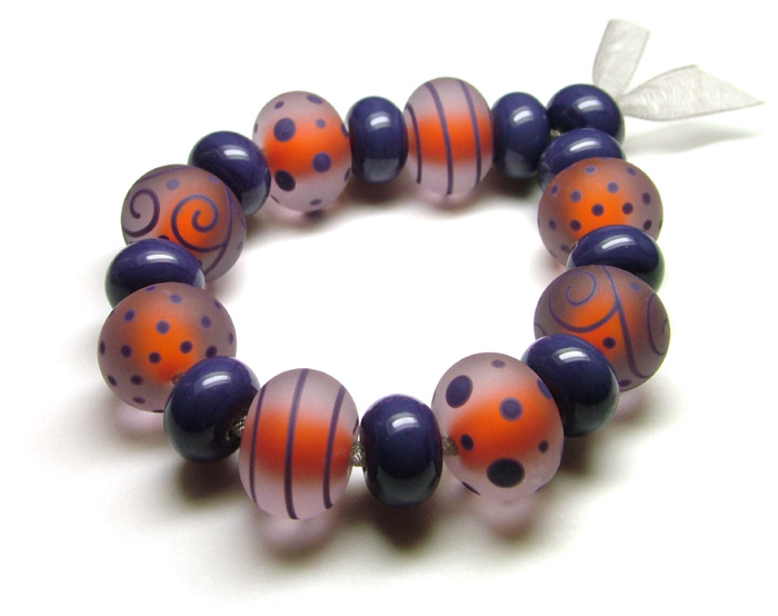 These orange beads have been encased in dusky rose and decorated with indigo