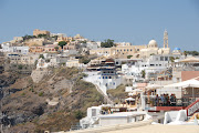 Fira perches atop the volcanic cliffs of. Santorini overlooking the caldera. (santorini )