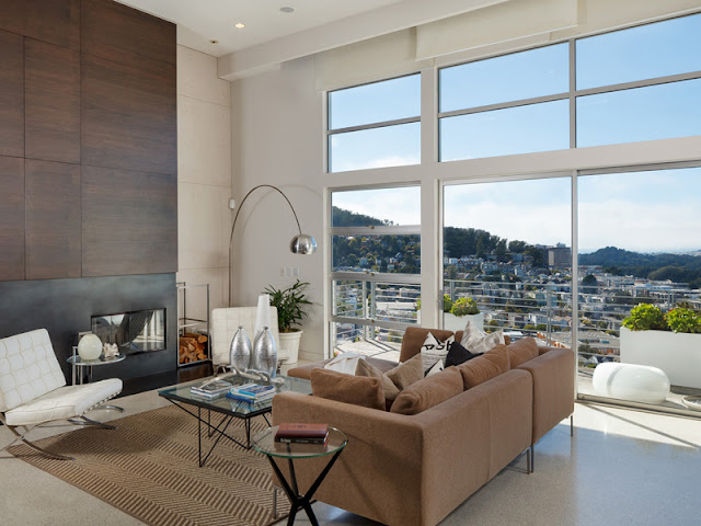 Picture of the small living room with fireplace and large windows overlooking the city