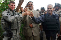 Capt. Benjamin Neasse (from left) celebrates raises a toast with a local contractor and Dean Michael, a bilingual bicultural adviser, to the completion of a water distribution system in the Muhmudiyah Qada Nov. 4, 2008.