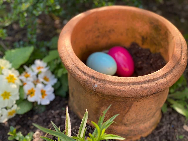 A flower pot with plastic eggs as part of an Easter Egg Hunt at home in Essex