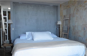 dormitorio con pared de piedra casa en ibiza chicanddeco