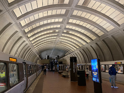 Photo of a platform under an arched roof. There are trains on both sets of track.