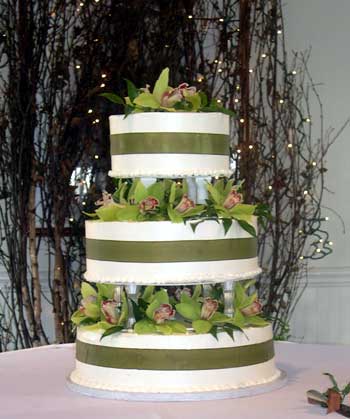 Whimsical green and white wedding cake set over four tiers white green