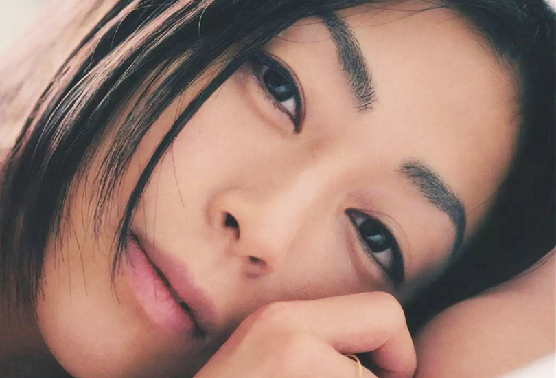 A close of shot of Hikaru Utada lying down, and looking into the camera.