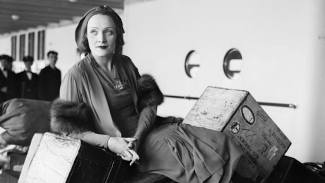 Marlene Dietrich amidst her luggage on her way to Hollywood and "divinity"