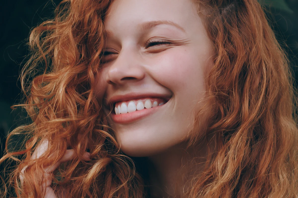 a portrait of smiling woman with red hair