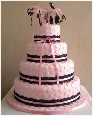 Light pink four tier cake with polka dots and black lace