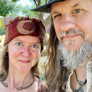 two people in Renaissance festival garb smirking at the camera