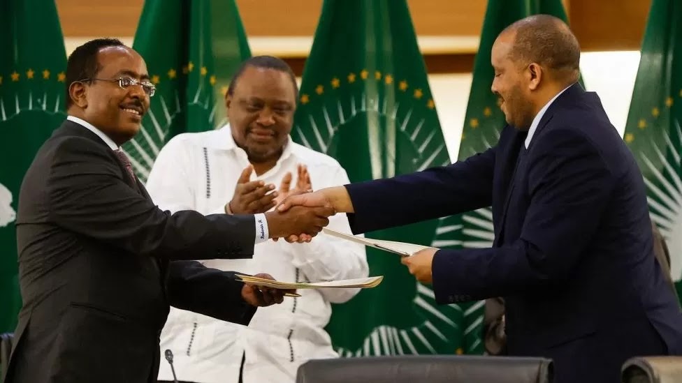 Redwan Hussien Rameto (L), Representative of the Ethiopian government, and Getachew Reda (R), Representative of the Tigray People's Liberation Front (TPLF), exchange documents after signing a peace agreement between the two parties, Nov 2, 2022.