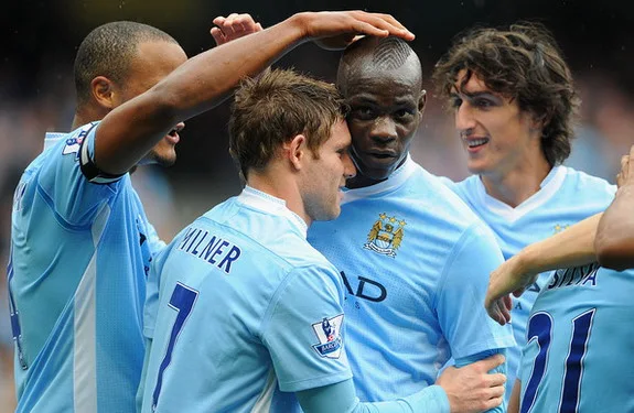 Mario Balotelli celebrates a goal with James Milner and his then Manchester City teammates