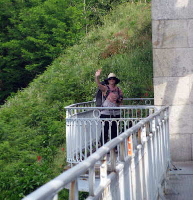 peregrina de Santiago acenando em cima da ponte de ferro entre Portugal e Espanha