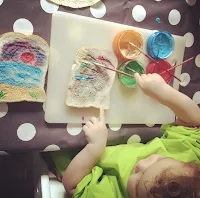 child painting bread with edible yoghurt paint