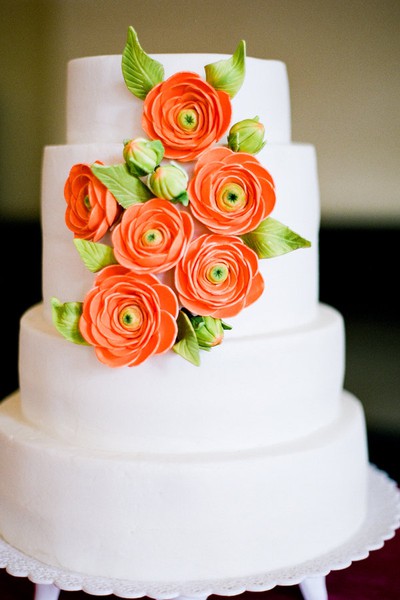 Beautiful wedding cake set over four round tiers in white with bold orange