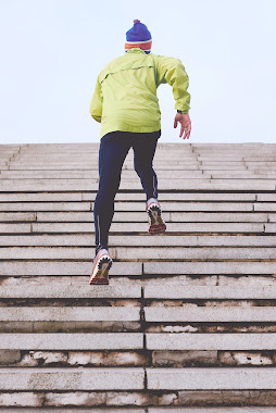 A man running outdoors on a sunny day.