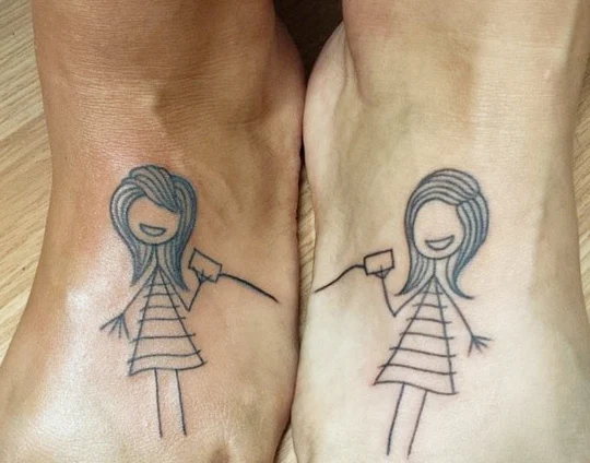 Los pies de dos chicas cada una con tatuaje de niña infantil con vasito a odo de telefono