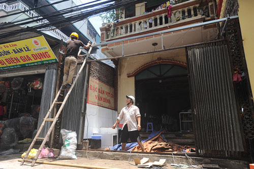 Anh Thực phải nghỉ bán hàng, gọi thợ đến sửa chữa phần hiên bị tốc mái do cơn giông chiều qua