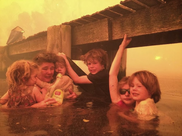 Тэмми Холмс и ее внуки укрываются под причалом во время лесного пожара в Австралии.