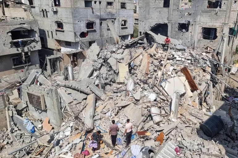 Palestinians look at the destruction after an Israeli airstrike in Rafah, Gaza [Mohammad Jahjouh/AP Photo]
