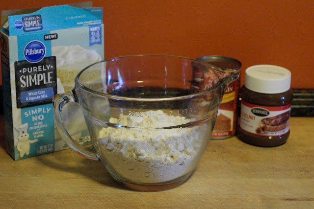 A mixing bowl, on the counter, with the powdered cake mix in it. 