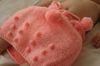 Neve wearing pink knitted pom-pom skirt.